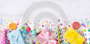 Birthday party banner or background with gift or present boxes, holiday supplies and confetti. Top view