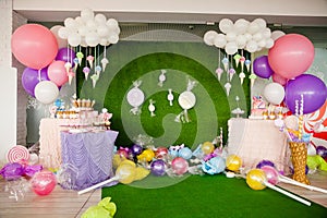 Birthday party concept, decorations for sweet party. Huge number one, table with sweets and desserts, cloud from balloons and ice-