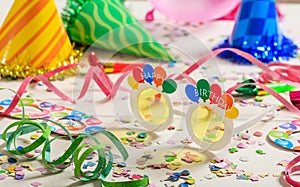 Birthday party. Confetti and serpentines on wooden background