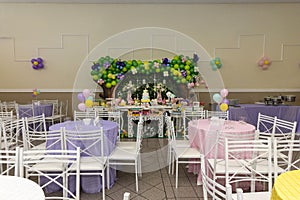 Birthday party decoration with tables, balloons, candies and cake.