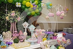 Birthday party decoration with tables, balloons, candies and cake.