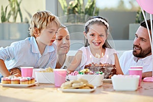 Birthday party, family and girl with cake for celebration, singing and candles at home. Happy portrait of kid, children