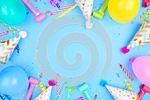 Birthday party frame on a blue background with confetti, balloons, party hats and streamers