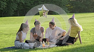 Birthday party. Guy teenager with cake with candles 17, celebrating birthday with friends