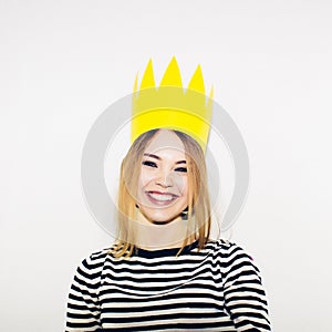 Birthday party, new year carnival. Young smiling woman on white background celebrating brightful event, wears stripped