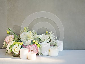 Birthday party or wedding flower arrangement with candles, white and pink roses.