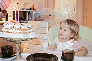 Birthday of a two-year-old girl, an appetizing cake with two burning candles