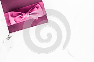 Pink gift box with silk bow on marble background, girl baby shower present and glamour fashion gift for luxury beauty brand,