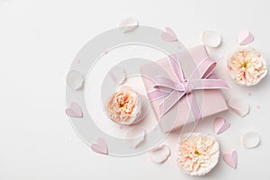 Birthday, Woman or Mothers Day greeting card. Pink hearts, rose flowers and gift box on pastel table top view. Flat lay