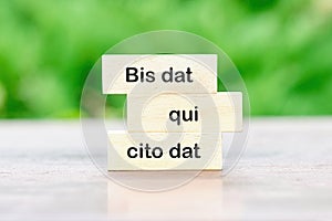 Bis dat qui cito dat It is translated from Latin as The one who gives twice is the one who gives quickly written on wooden blocks photo