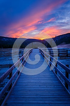Biscuit basin walkway with blue steamy water and beautiful colorful sunset. Yellowstone, Wyoming