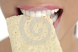 Biscuit in woman teeth and mouth, healthy snack