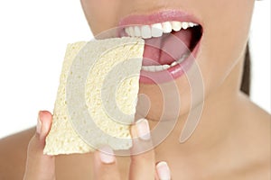 Biscuit in woman teeth and mouth, healthy snack