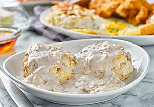 Biscuits and gravy with sausage on plate photo