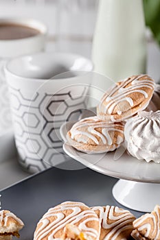 Biscuits on gray plate with cups of coffee and bottle of milk