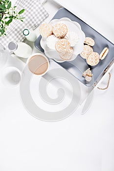 Biscuits on gray plate with cups of coffee with green and white