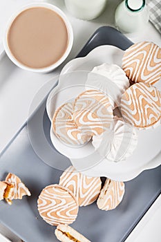 Biscuits on gray plate with cups of coffee, top view