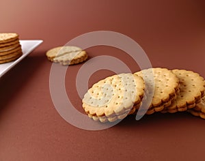 biscuits on white dish and isolated, round biscuits on brown background,close up