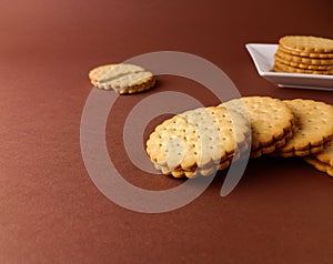 biscuits on white dish and isolated, round biscuits on brown background,close up