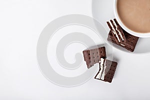 Biscuits on white plate and cup of coffee, top view