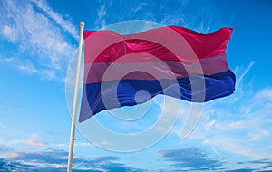 Bisexual Pride flag waving in the wind at cloudy sky. Freedom and love concept. Pride month. activism, community and freedom photo