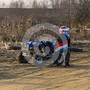 A small boy and his quad which has broken down.