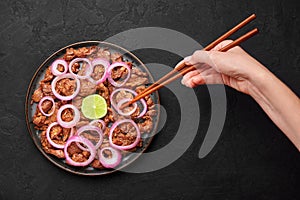 Bistek Tagalog or Bistec Encebollado on black plate on slate table top. Filipino spanish cuisine beef steak with onion photo