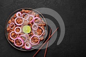 Bistek Tagalog or Bistec Encebollado on black plate on slate table top. Filipino spanish cuisine beef steak with onion photo