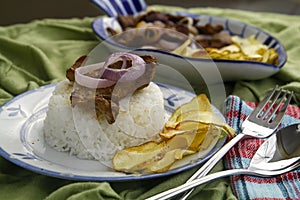 Bistek Tagalog or fried pork tenderloin in soy sauce with potato chips photo