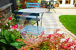 Bistro set at an end of the Summer garden, with autumnal reds photo