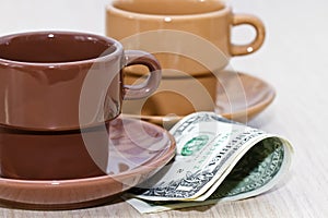 Bit of cash lying under an empty coffee Cup