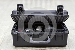 Bit open plastic case on floor with photo equipment in dividers