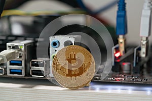 Bitcoin against the background of the motherboard in the rack for the crypto currency mining