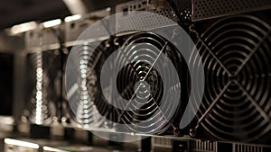 Bitcoin ASIC miners in warehouse. ASIC mining equipment on stand racks for mining cryptocurrency in steel container. Fan
