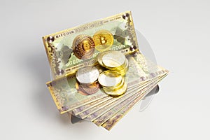 Bitcoin banknotes and golden btc coins on the treasure trove, cryptocurrency in wooden chest, gift, decoration on white paper