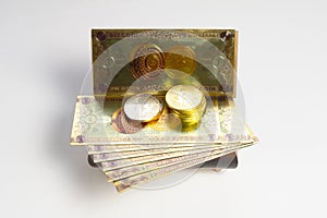 Bitcoin banknotes and golden btc coins in the treasure trove, cryptocurrency in wooden chest, gift, decoration on white paper