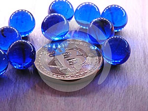 Bitcoin with blue glass marbles.