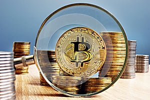 Bitcoin BTC, coins and magnifying glass. photo