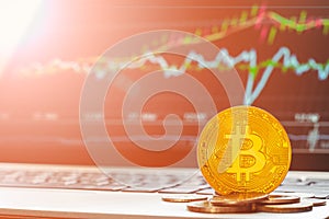 Bitcoin BTC cryptocurrencies with rising bullish graph laptop display in background. The bitcoin stock trading background concept