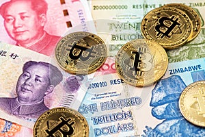Bitcoin BTC cryptocurrency coins on China Yuan Renminbi and Zimbabwe hyperinflation Dollar currency banknotes close up image. photo