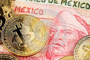 Bitcoin BTC cryptocurrency coins lying on Mexican Pesos currency banknotes.