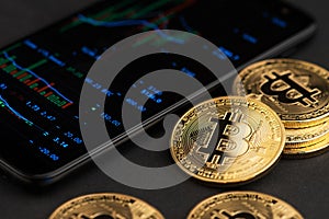 Bitcoin BTC cryptocurrency coins virtual money next to mobile phone. BTC vs USD Stock Exchange photo