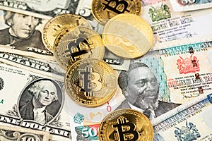 Bitcoin BTC cryptocurrency coins virtual money on US Dollar and Kenyan Shilling banknotes.