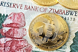 Bitcoin BTC cryptocurrency coins and  Zimbabwe hyperinflation banknote. Africa Bitcoin