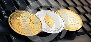 Bitcoin BTC, Ethereum ETH, Litecoin LTC coins over laptop keyboard