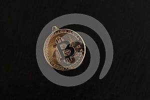 Bitcoin coin as keychain on black background. Cryptocurrency, mining concept