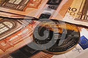 Bitcoin coin on banknotes background close-up. Bitcoin symbology photo