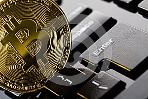 Bitcoin coin on black keyboard
