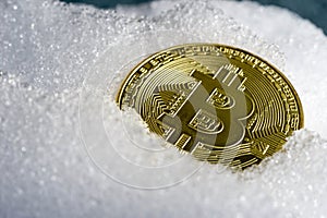 Bitcoin coin on ice or snow