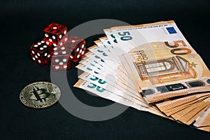 Bitcoin coin, a pile of Euro banknotes and a few red cubes lie side by side on a dark background